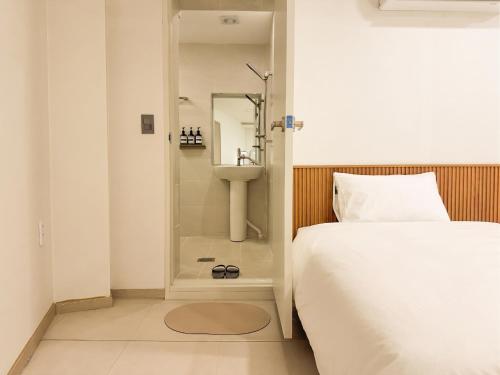 a bedroom with a shower and a bed and a sink at 아문 스테이 in Busan