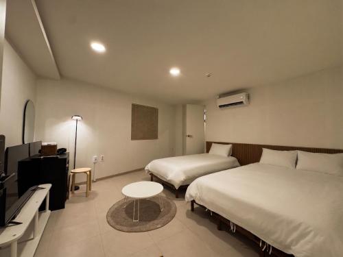 a hotel room with two beds and a table at 아문 스테이 in Busan