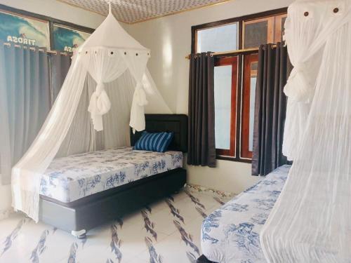 a bedroom with a bed with a canopy at Tirosa in Nembrala