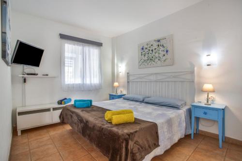 a bedroom with a bed and two tables and a tv at Piccola Oasi Corralejo in Corralejo