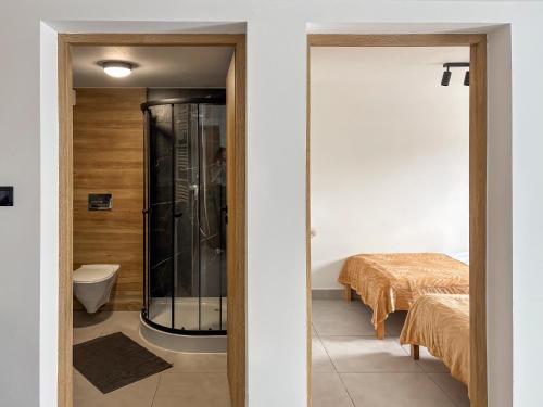 a bathroom with a shower and a bed in a room at Apartamenty Piotrowice in Piotrowice