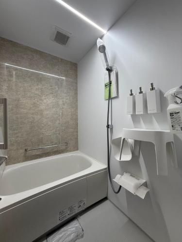a white bathroom with a shower and a bath tub at Koyuki Kimobetsu in Abuta