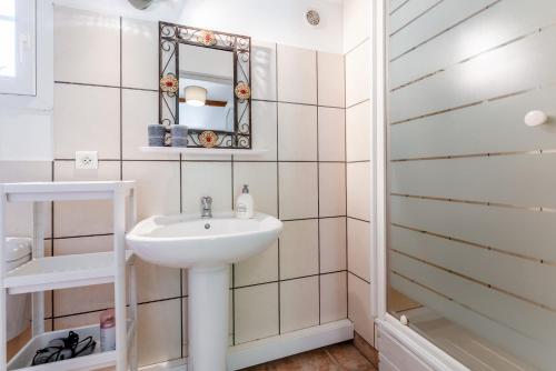 a white bathroom with a sink and a mirror at Chambres D'hôtes Les Seignerolles in Pernes-les-Fontaines
