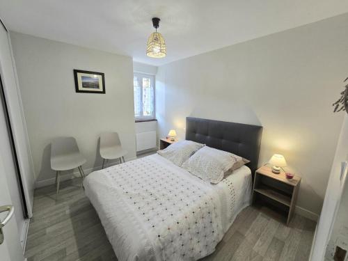 a bedroom with a bed with two chairs and a table at Chez eugénie in Génis
