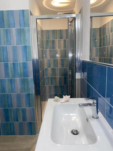 a bathroom with a white sink and a shower at Il Piccolo Cristallo sul Mare in Santa Marinella