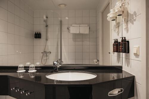 a bathroom with a sink and a shower at Home Hotel Aurora in Tromsø