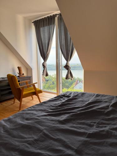 a bedroom with a bed and a large window at Danube House in Mohács