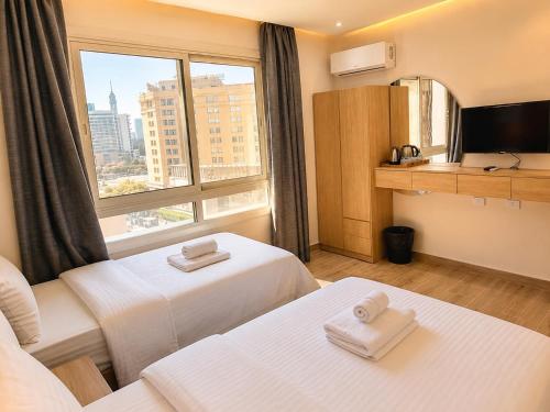 a hotel room with two beds and a window at Landmark Hostel Cairo in Cairo