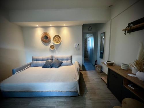 a bedroom with a large white bed with blue pillows at Kleopatra's Apartments in Chios