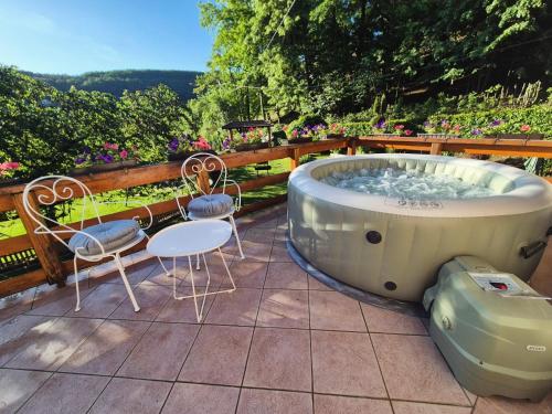 a bath tub sitting on a patio with a table and chairs at Banja Luka house - Casa Rustica in Banja Luka
