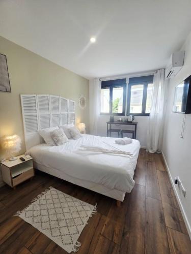 a white bedroom with a large bed and a window at Chambre Premium "Plume"- SDB privée & coin repas in Sainte-Geneviève-des-Bois