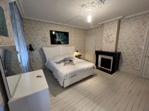 a bedroom with a white bed and a fireplace at Chambre bleue in Vigneulles-lès-Hattonchâtel