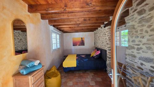 a bedroom with a bed and a stone wall at Le Relais de Saint Germain in Saint-Germain-les-Belles