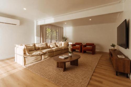 a living room with a couch and a table at Casa Airlie in Airlie Beach