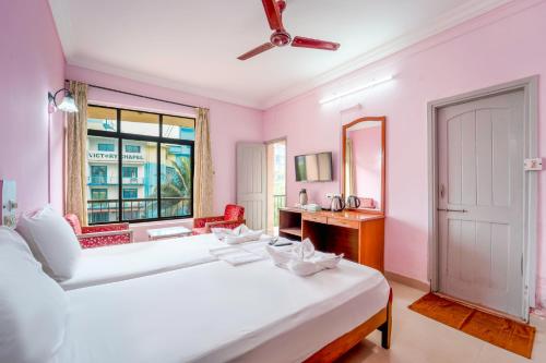 a bedroom with a large white bed and a window at Margao Residency in Madgaon