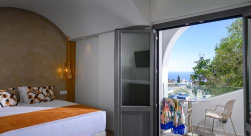 a bedroom with a bed and a balcony at Anemone Luxury Suites in Fira