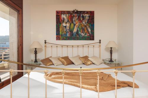 a bed in a room with a painting on the wall at Lets Holidays INCREDIBLE APARTMENT WITH AMAZING VIEWS in Tossa de Mar