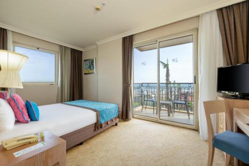 a hotel room with a bed and a balcony at Crystal Family Comfort Collection - Ultimate All Inclusive in Belek
