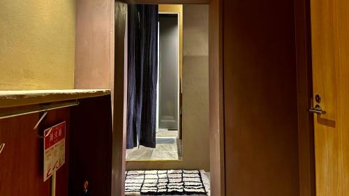an open door to a room with a mirror at MAGATAMA.INN in Sumoto