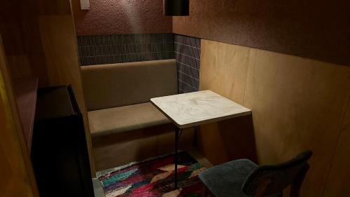 a small room with a bench and a table at MAGATAMA.INN in Sumoto