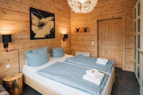 a bedroom with two beds and a chandelier at Chalet Hahnenklee in Goslar