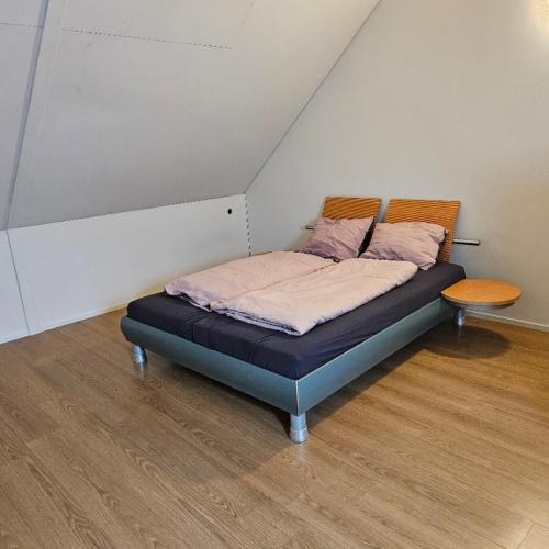 a bed in the corner of a room at Residence Oosterhout in Den Hout
