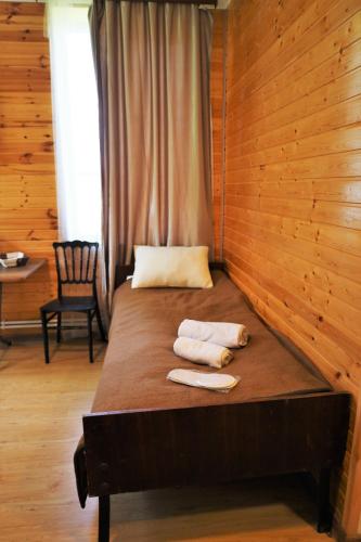 a bed in a wooden room with towels on it at MAKO in Racha in Ambrolauri