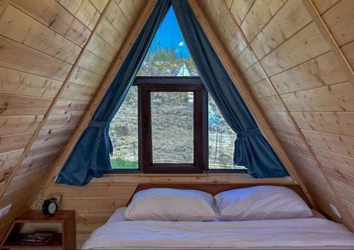 a bed in a room with a large window at IN CLOUDS RESORT Byurakan in Antarut