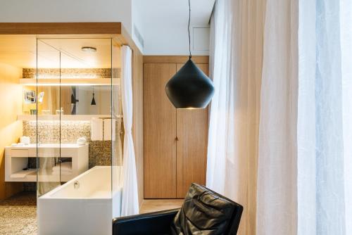 ein Zimmer mit einem schwarzen Stuhl und einem Spiegel in der Unterkunft B2 Hotel Zürich in Zürich