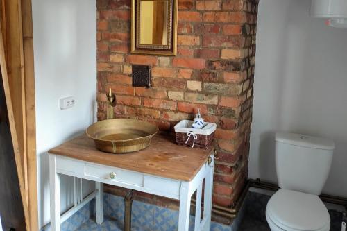 a bathroom with a bowl on a table next to a toilet at Хатуля in Oleshnya