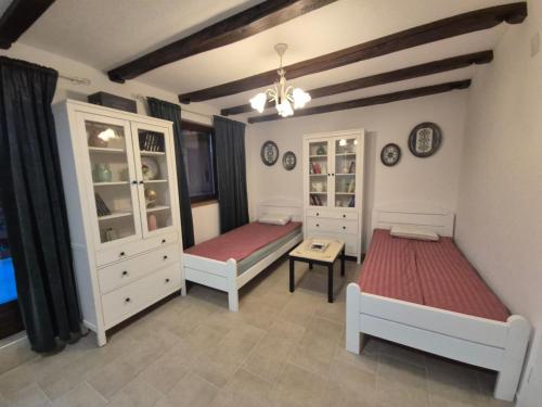a bedroom with two beds and white cabinets at Banja Luka house - Casa Rustica in Banja Luka