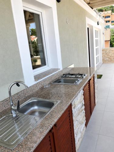 a kitchen counter with a sink and a window at Losinj Panorama Penthouse in Mali Lošinj