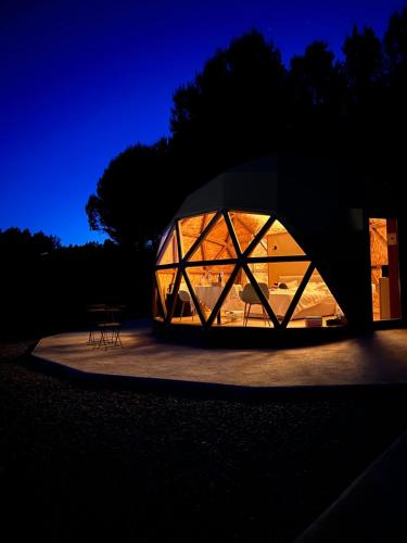 a large glass dome building with a table inside at El Molí Glamping Escapada Romántica in Adzaneta