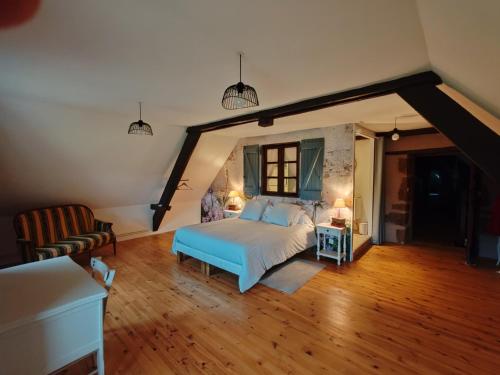 a large bedroom with a bed and a couch at Sans Chichi Chambres Et Table in Escandolières