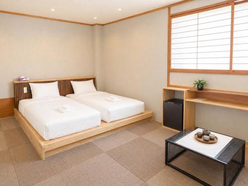 a bedroom with two beds and a window at Zao Sunvalley Hotel in Yamagata