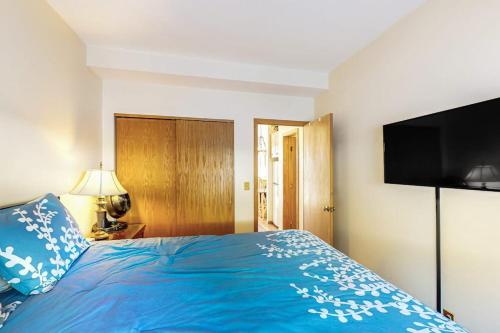 a bedroom with a blue bed with a flat screen tv at Timber Ridge 504B in Silverthorne