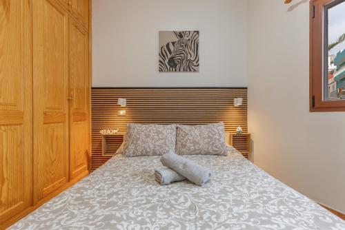 a bedroom with a large bed with a wooden headboard at Las Sirenas 2 in Las Palmas de Gran Canaria