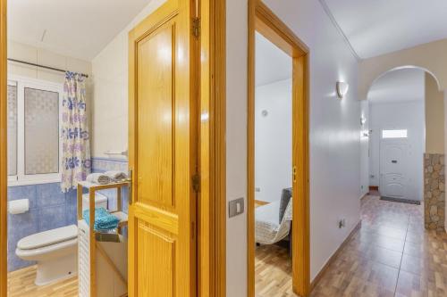 a bathroom with a toilet and a door to a room at Las Sirenas 2 in Las Palmas de Gran Canaria