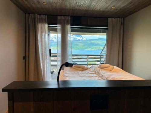 a bedroom with a bed and a window with a view at Aa-Gård in Tennevoll