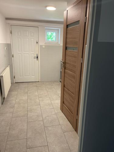 a bathroom with a door and a tiled floor at Kwatera przed remontem BEZ zlewu w części kuchennej łazienka sprawna ale PRZED REMONTEM in Gdynia