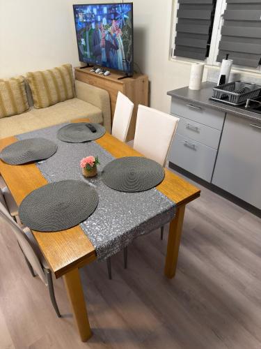 a table with four plates on it in a living room at Apartman J&B in Vir