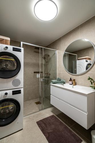 a bathroom with a washing machine and a sink at Mountain View Apartment, Free Parking, Hiking Nearby in Ålesund