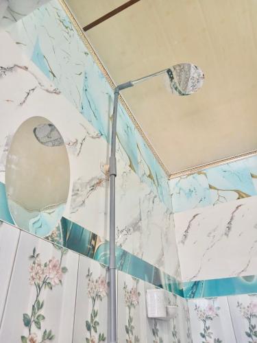 a shower in a bathroom with marble walls at Tirosa in Nembrala