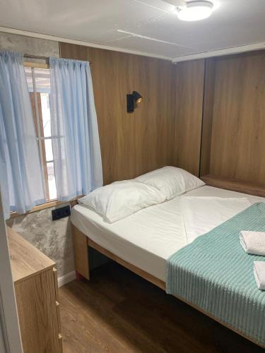 a small bedroom with a bed and a window at Hostel CAPS HOME boutique in Astana