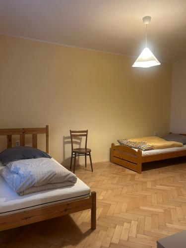 a bedroom with two beds and a chair at Your home 29 with parking in KoÅ¡ickÃ© KÃºpele