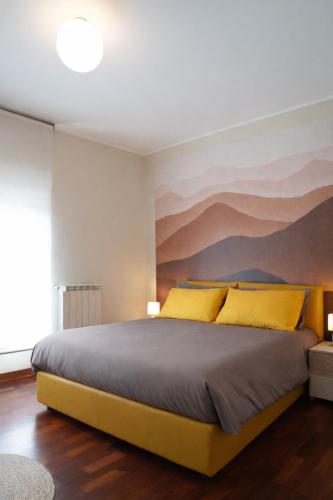a bedroom with a large bed with yellow pillows at Fiuggi Terme Bonifacio Apartment in Fiuggi