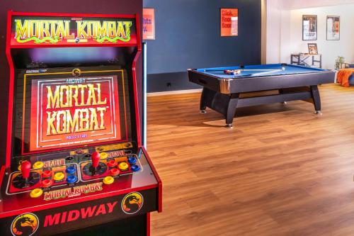 a pinball machine and a pool table in a room at The Great View Sauna & more in Harscheid