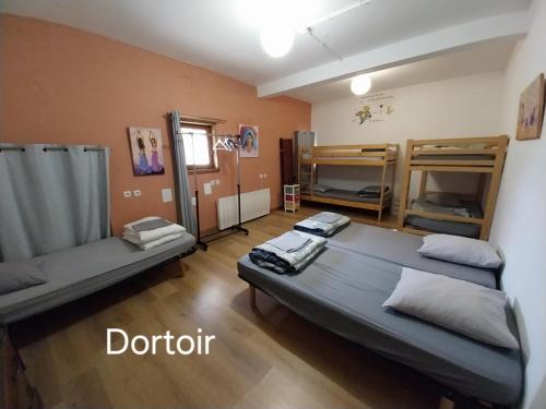 a room with a bed and bunk beds in it at gîte 19 personnes in Rogues