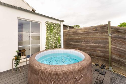 a hot tub on a deck next to a fence at The Great View Sauna & more in Harscheid