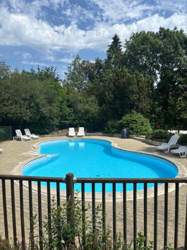a swimming pool with chairs and a fence at Camping Terre d'Armor in Bourseul